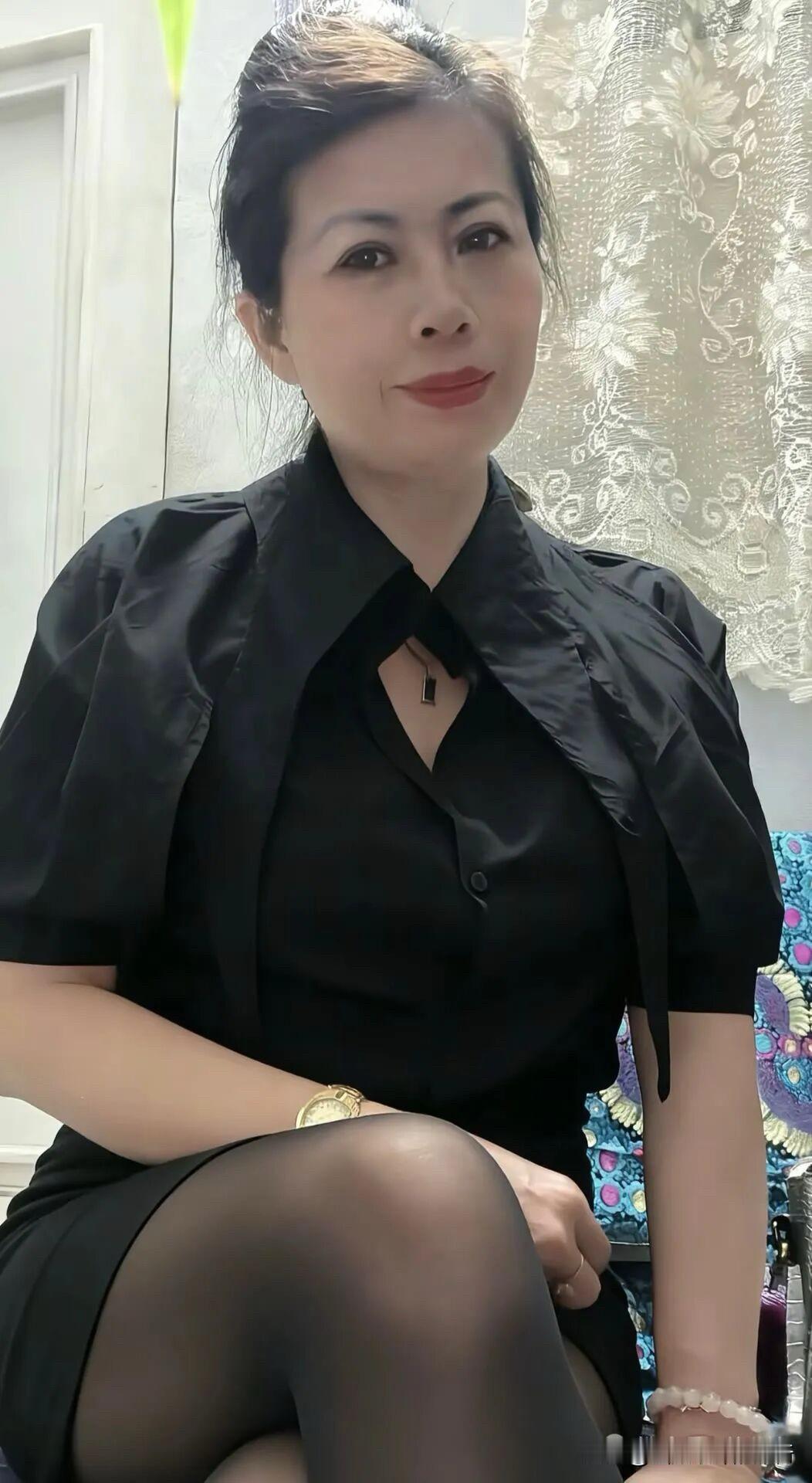 黑衫裁出利落的弧，金表与珠串私语，每个姿态都浸着从容的优雅。蕾丝帘幕漫着柔，