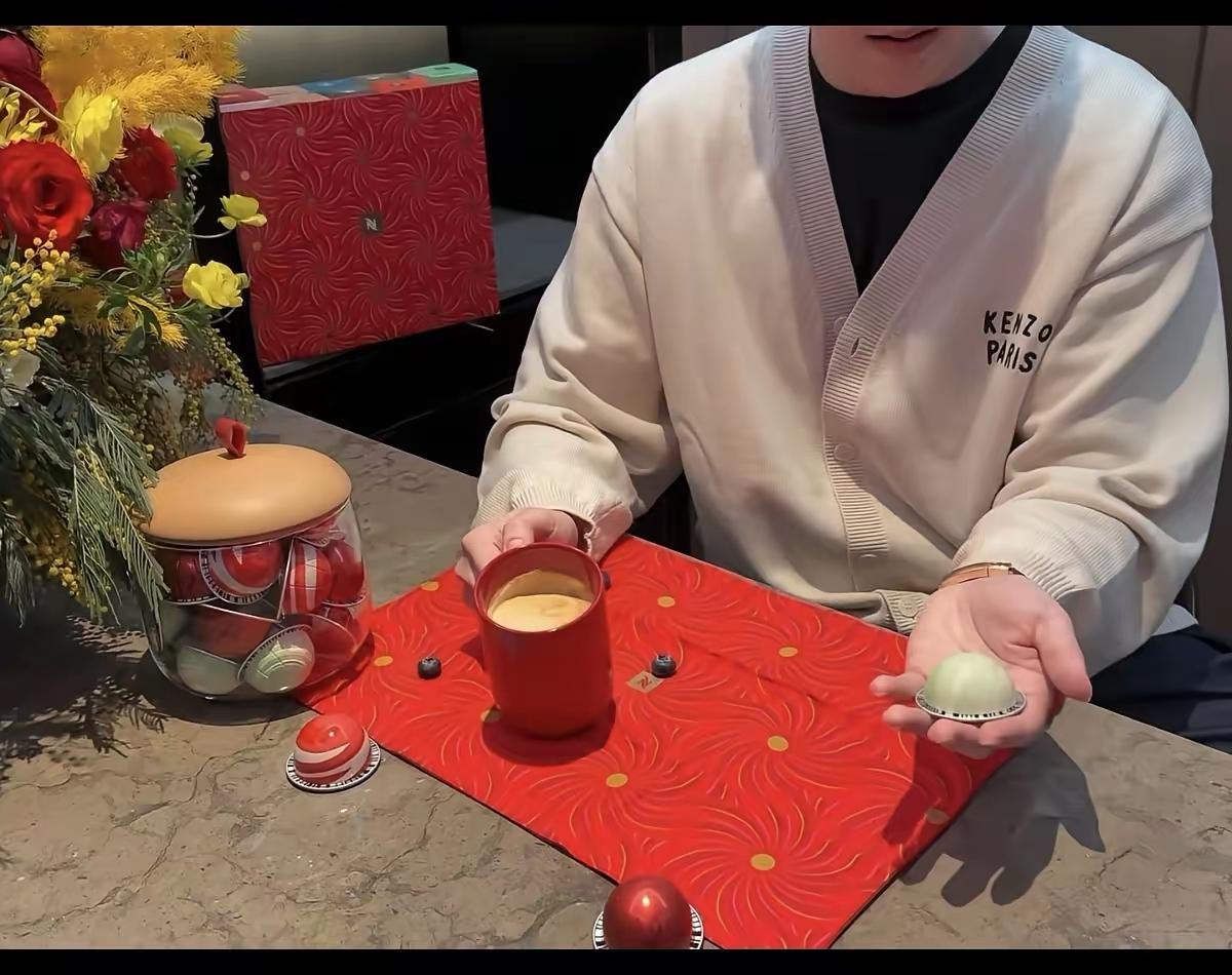 头哥今天更新的动态，罕见地没有露脸，右手轻触一杯咖啡，左手把玩一个球形的东西；第