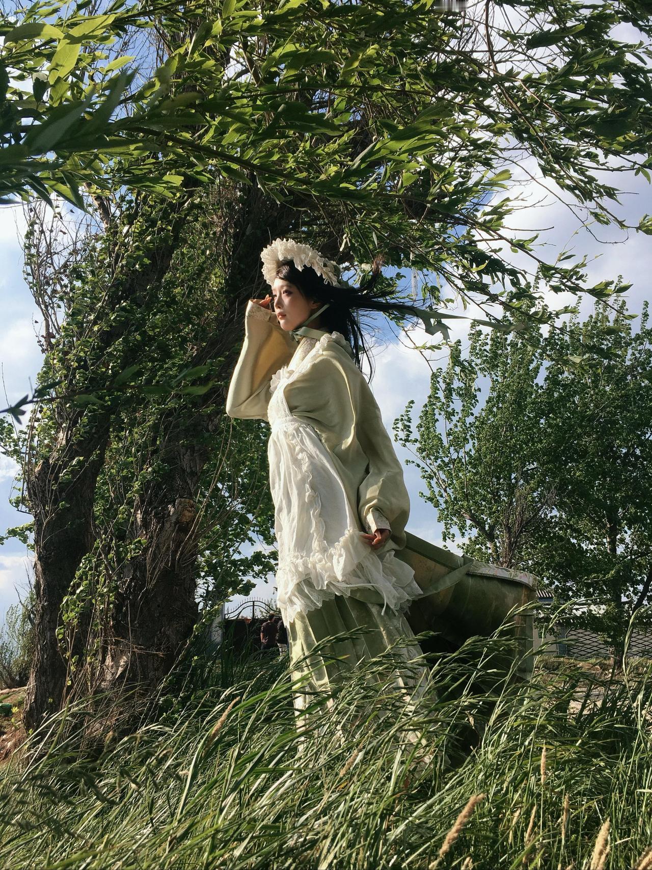 作品以户外草地为拍摄场景，聚焦春日少女的柔美气质，呈现出极具故事感的人像画面。构