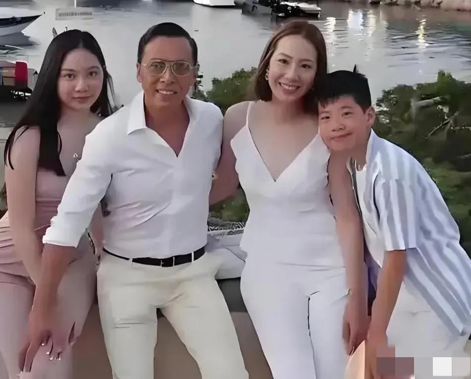 甄子丹一家四口出去游玩时的合照：妻子汪诗诗身材高挑，柳眉杏眼，笑容甜美；女儿长发