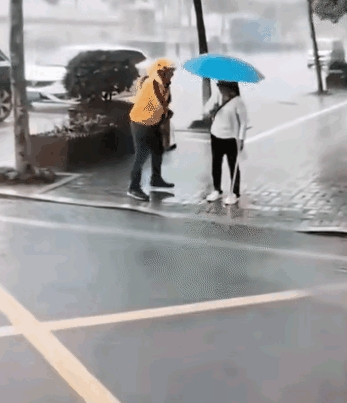 太感动了！有一名外卖小哥冒着雨前去送餐，看到路边有一名失明的女子撑着伞，一直站在