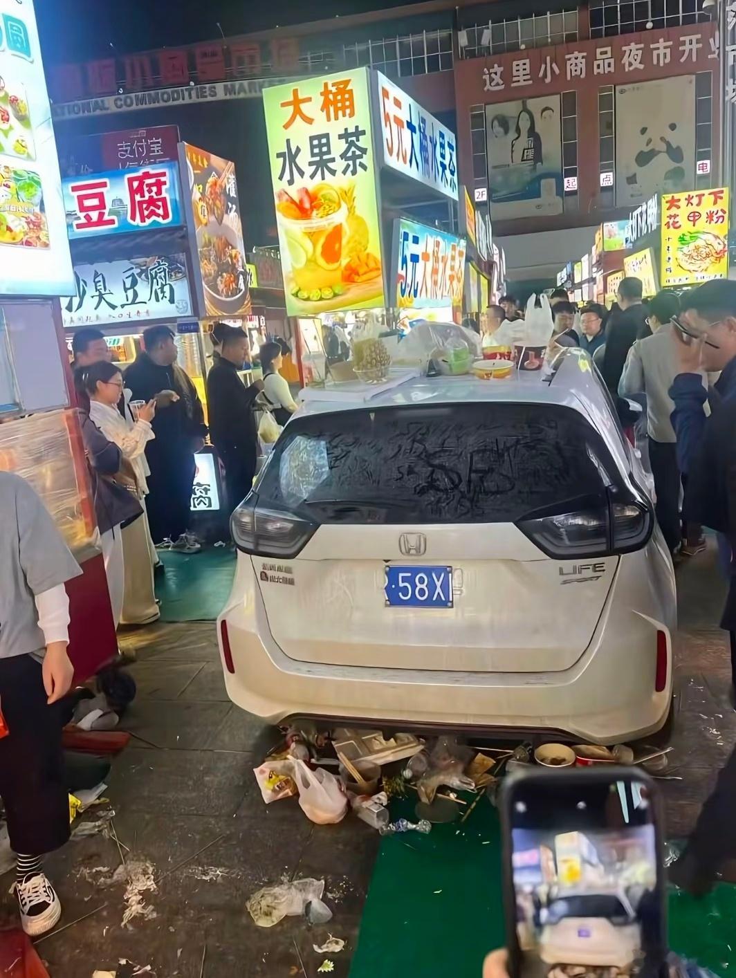 小车在夜市未及时挪走被丢满垃圾这个停车场白天是停车场，晚上是夜市摊。如果你的车