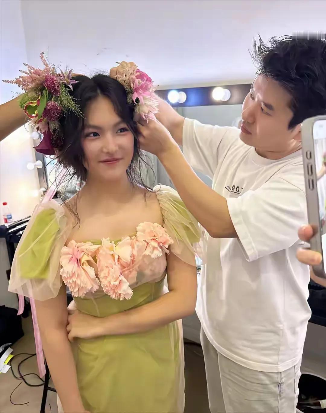 王诗龄一身绿裙，还有人帮忙给她头戴鲜花，这女孩子生来就是享受人生的，只因她会投胎