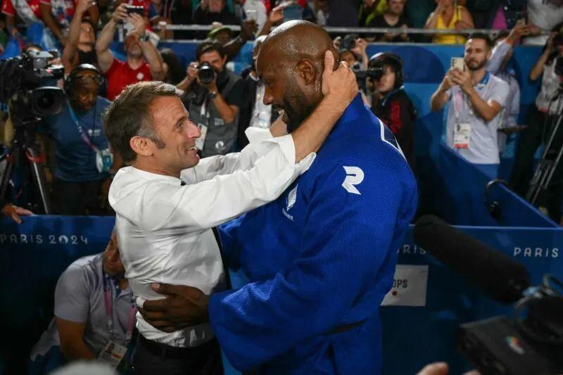 马克龙在黑人身旁好娇小，皮肤白皙的他显得挺小鸟依人的。