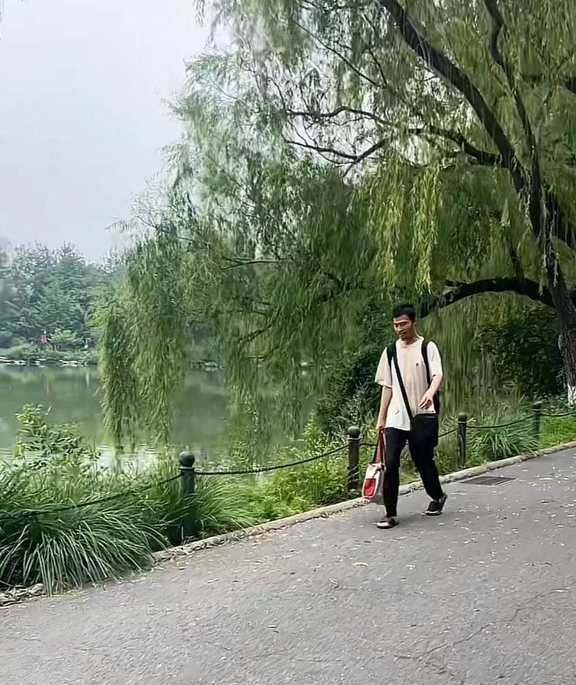 同学又碰到韦神了，这次在一个湖边，穿着大拖鞋，走得特匆忙，身上背个包，前面挎个包
