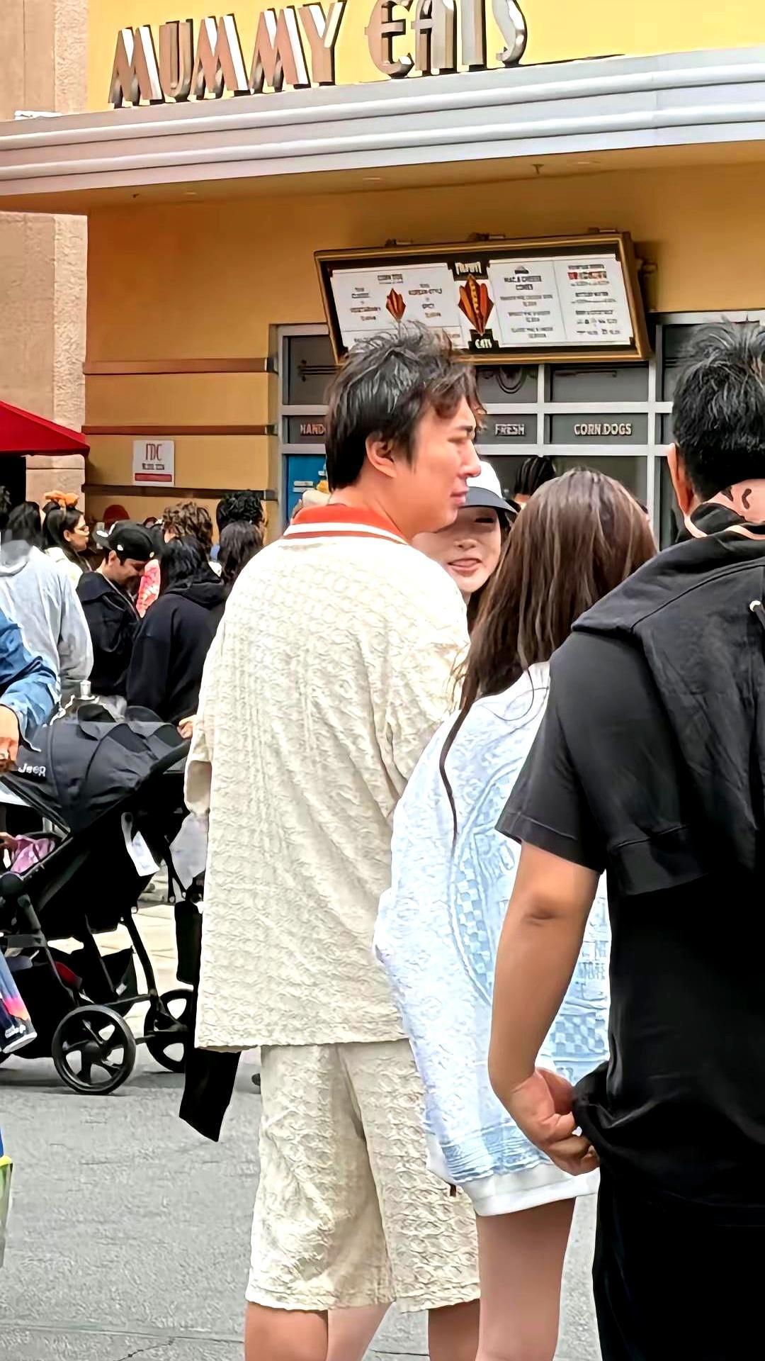 在国外的环球影城夜里，睡衣拖鞋、素面油头，一个熟脸被围住了。王思聪。身边还