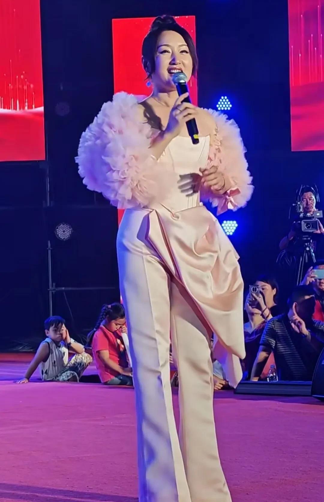 “甜歌皇后”杨钰莹现身商演，54岁的她，穿着一身粉色，脸肿脸僵，医美痕迹很明显，