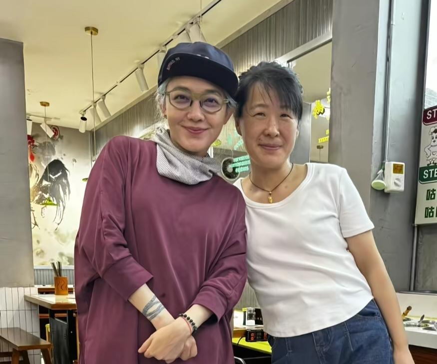 48岁范晓萱在安徽一家餐馆吃火锅，和老板娘一起合影，穿衣打扮一言难尽，看起来非常