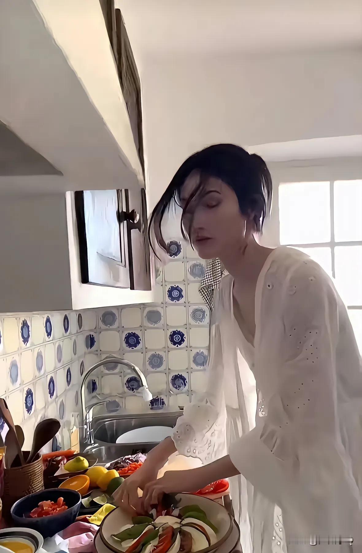 何穗这几张下厨的照片怕是摆拍的吧，不然，哪有人下厨会是这样的状态。身着飘逸的白