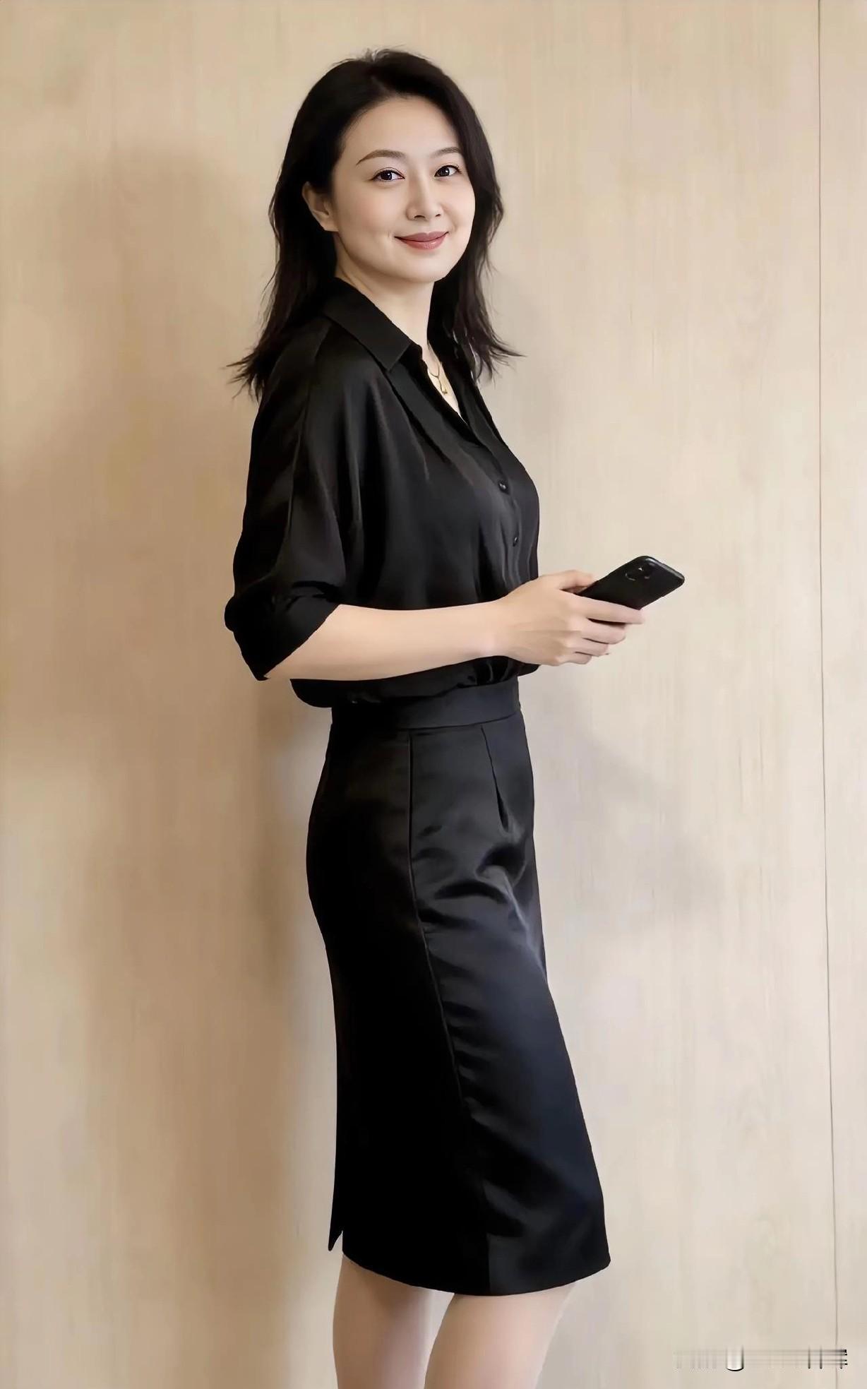 黑裙摇曳生姿，笑意温婉如诗，静立间自成风景。
