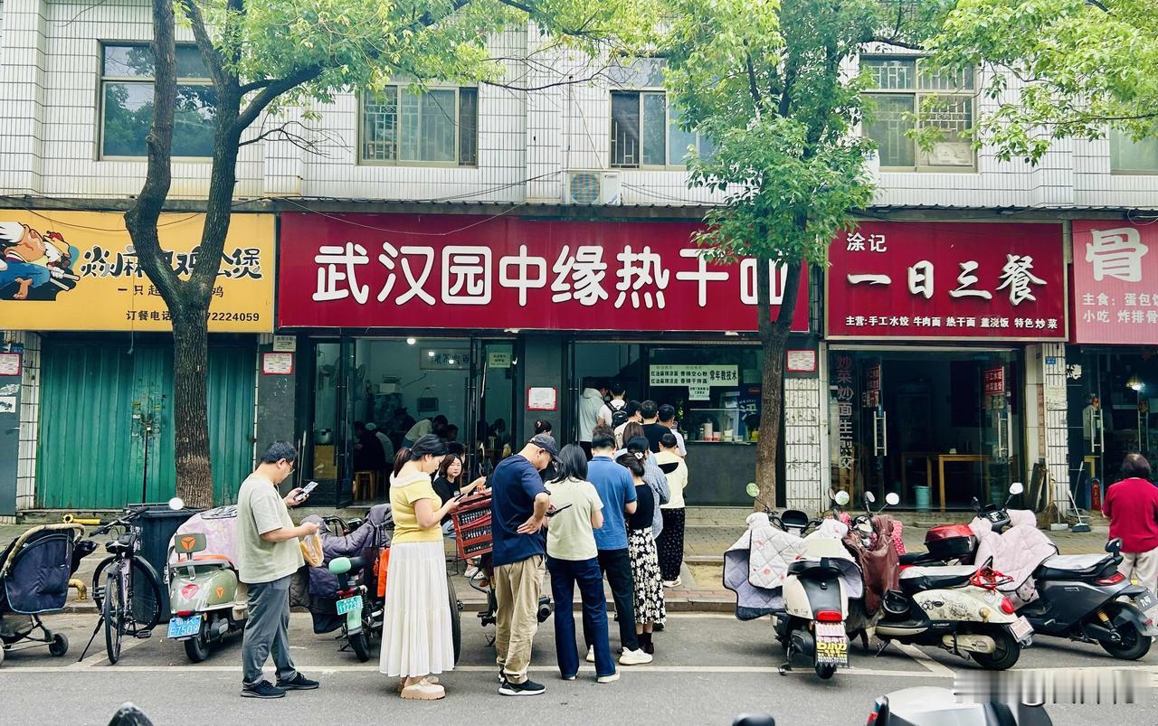 热干面馆前排起长队（随手拍）。不知为何，这家热干面馆向来顾客众多，早上往往要排起