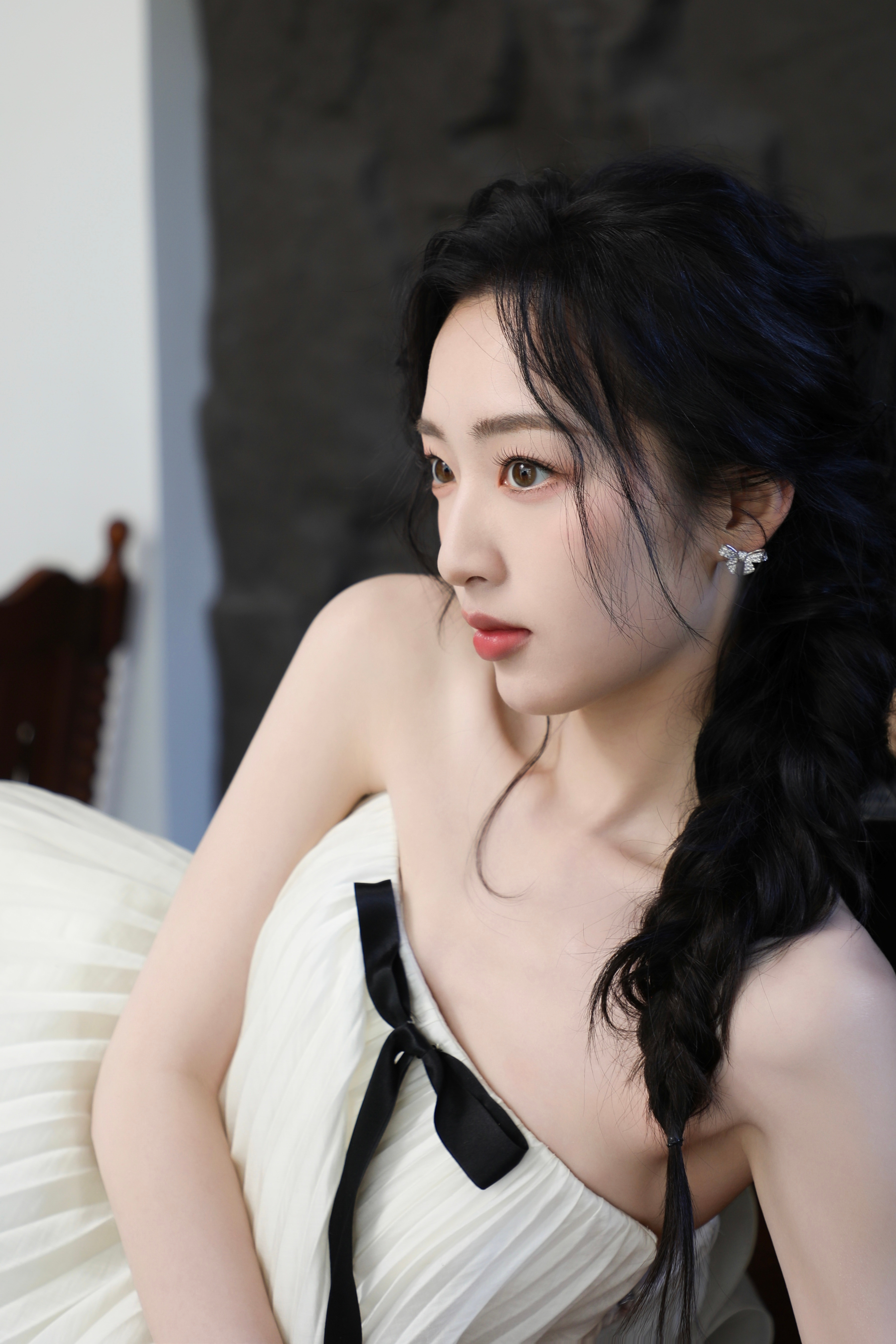 邓恩熙黑蝴蝶结在白裙间轻缀，麻花辫挽起温柔，她似从复古梦境中走来，于光影里漾开