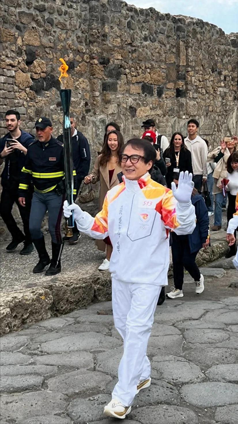 71岁成龙现身庞贝古城！白发戴眼镜举火炬，一个动作让全网沸腾他一路微笑挥手，粉