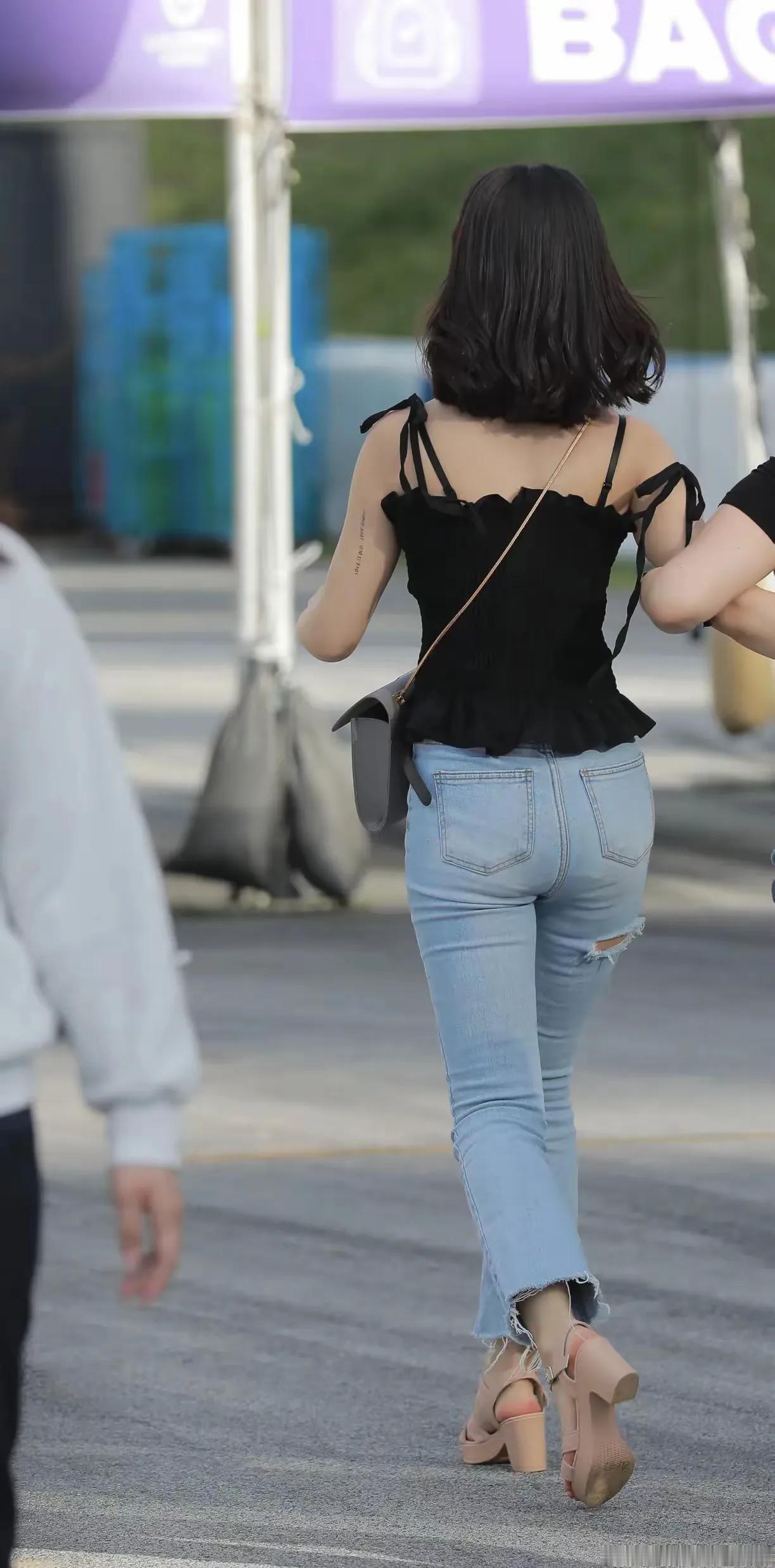 一个女孩穿着黑色上衣和牛仔裤在走路。为什么健身的女性都爱穿紧身裤牛仔裤都有哪些