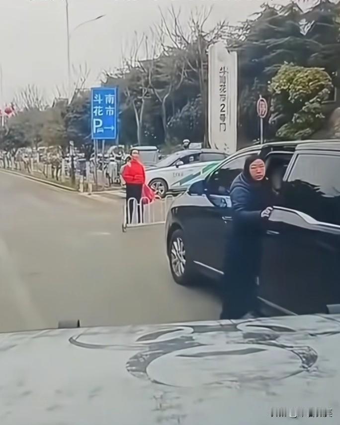 女子违停整理物品，等待拐弯的男子按了一下喇叭提醒，没想到女子把马路当成了自家的客