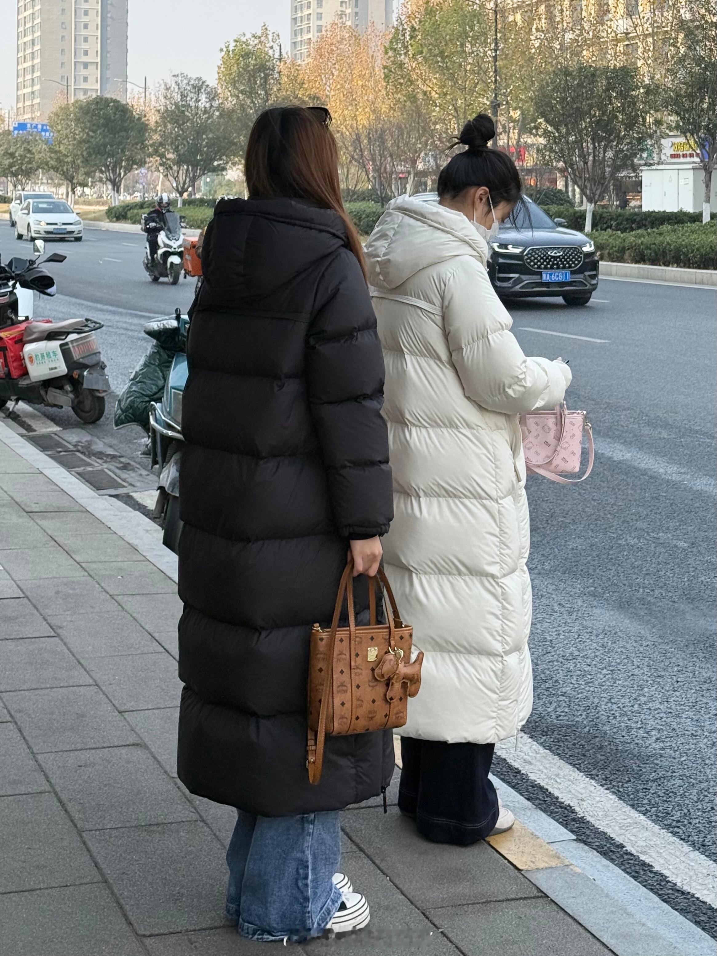 不er?这是今年流行的羽绒服趋势吗？公交站公交站看到的，这两个姐妹的长款羽绒服好