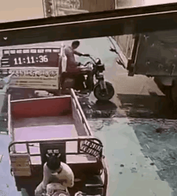 只有短短的1秒钟！三轮车停在大货车后面，突然一下被后面的白色轿车追尾，三轮车被撞