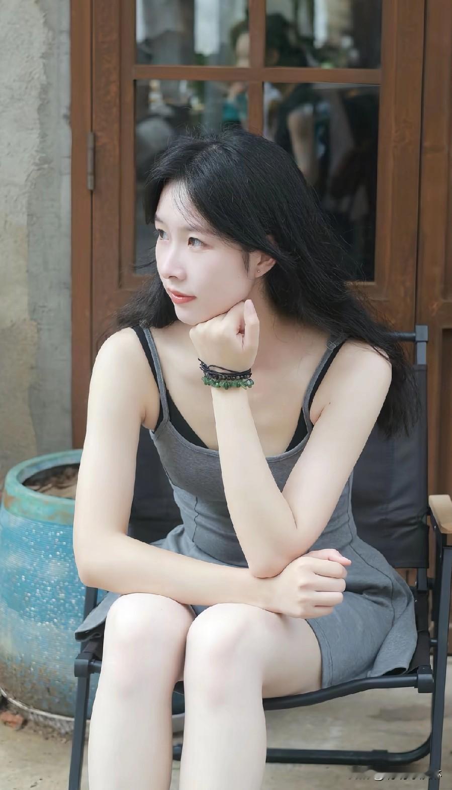 沉思的午后，黑发少女静坐，绿植相伴，时光静好。