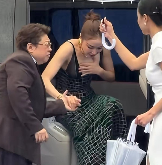 韩红和高叶一同出席北京国际电影节现场下着瓢泼大雨，韩红下车后紧皱眉头，立刻转身