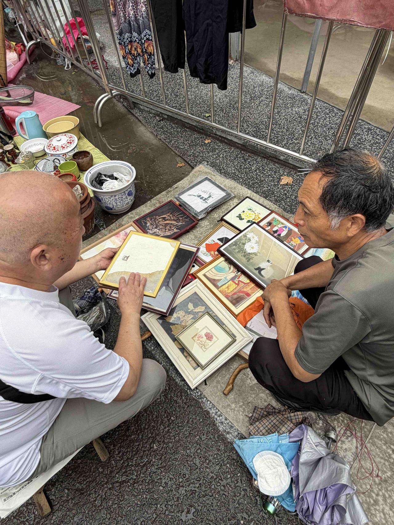 昨天上午，我逛西安档子，走到西仓南巷时，看到卖工艺画的老板，搬过小凳子，让蹲着挑