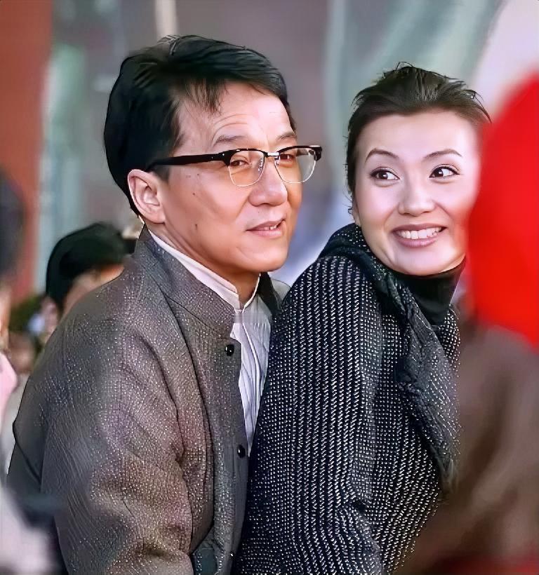 成龙大哥头发乌黑，戴着眼镜，气质还是比较大方的，他突然出现，把女明星给惊讶到了，