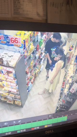 一名年轻女子在超市里购物，当她蹲下来挑选商品的时候。她身后的裙摆正好挂住了货架