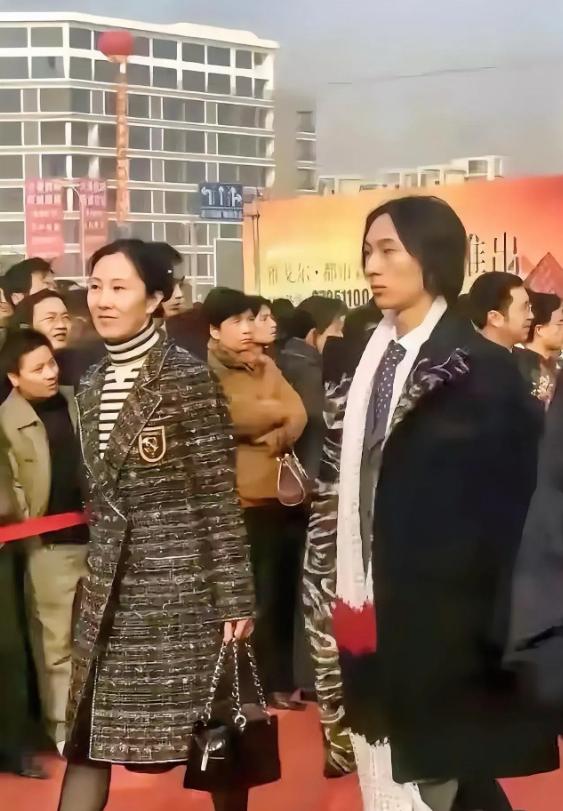 当年的王思聪随母亲林宁出席活动时的照片，长发长衣长围巾，面容严肃，妥妥一个典型文