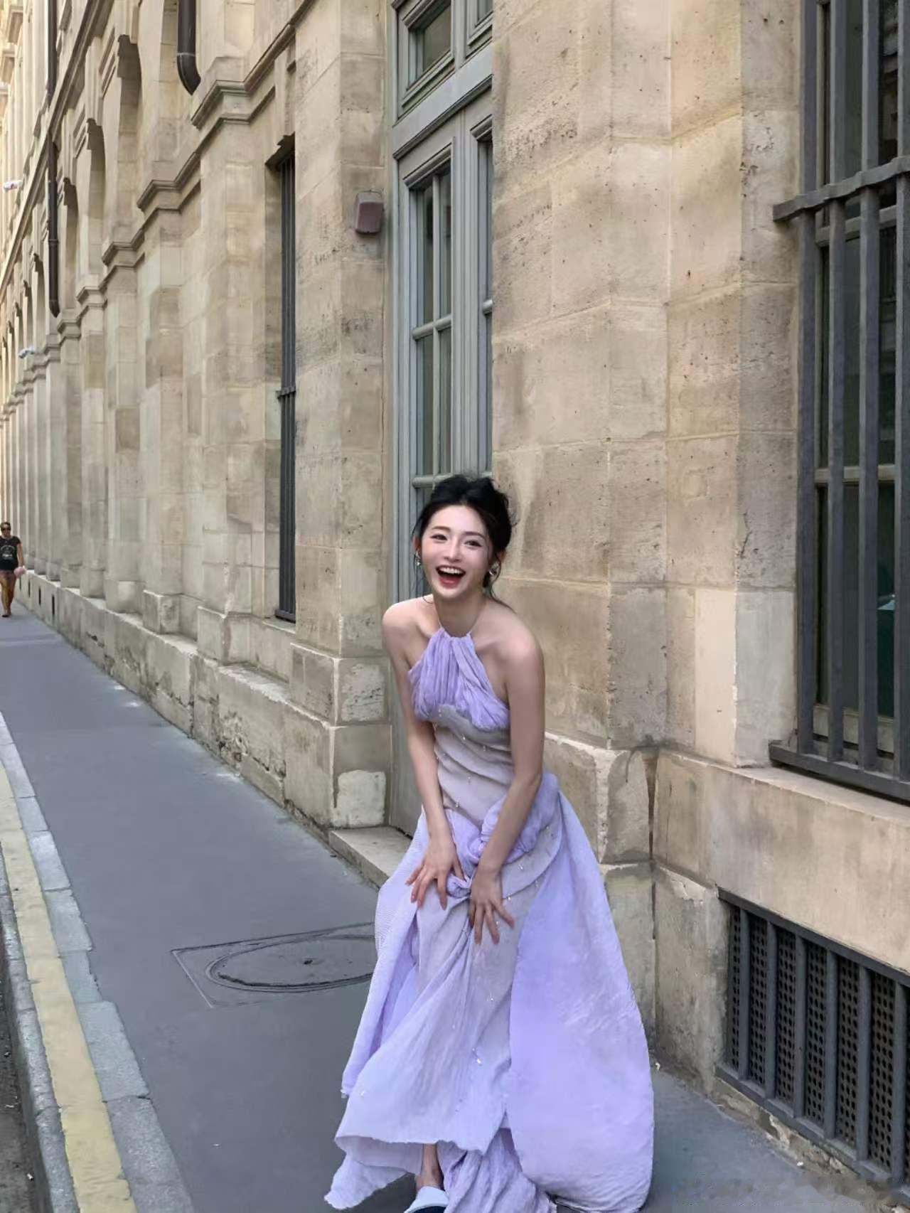 周洁琼裸背挂脖裙巴黎落日铺在街道上，淡紫长裙伴着晚风轻晃，裸背线条裹着柔光，每