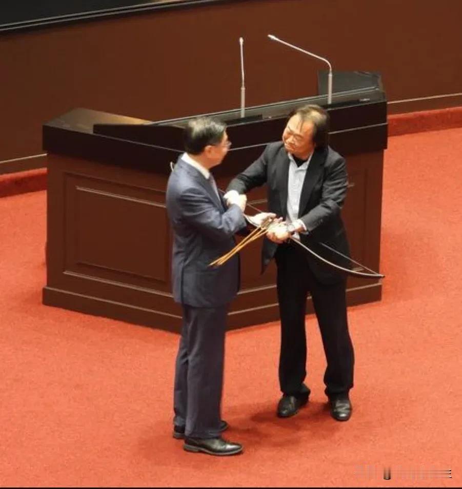 民进党立委王世坚今天在台湾地区立法机构质询行政机构负责人卓荣泰时，拿出一把弓箭送