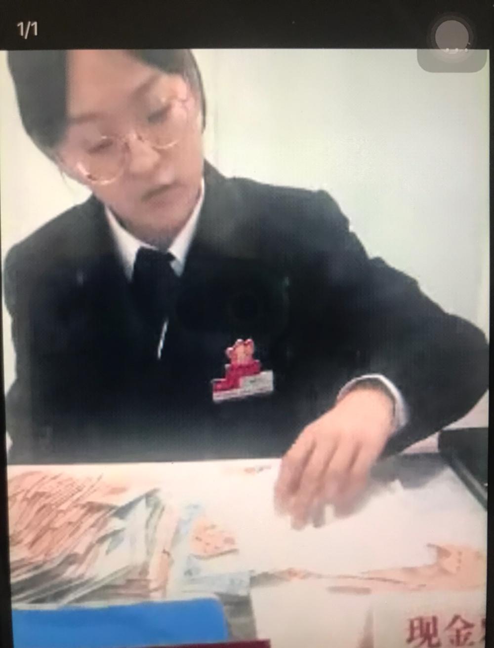一名拾荒老人到银行存钱，当老人从裹了几层脏兮兮的塑料袋里把钱拿出来，递到银行窗口