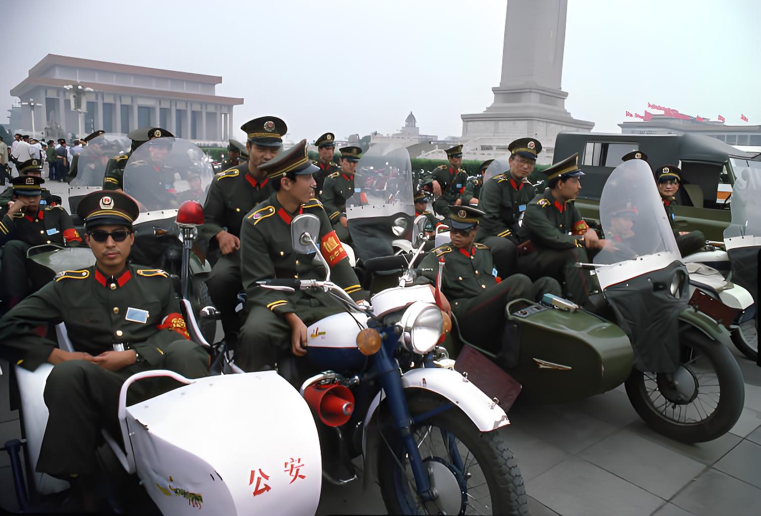 这张照片呈现了1979年左右北京市中心广场上的一幕。画面中，身着制服的公安民警坐