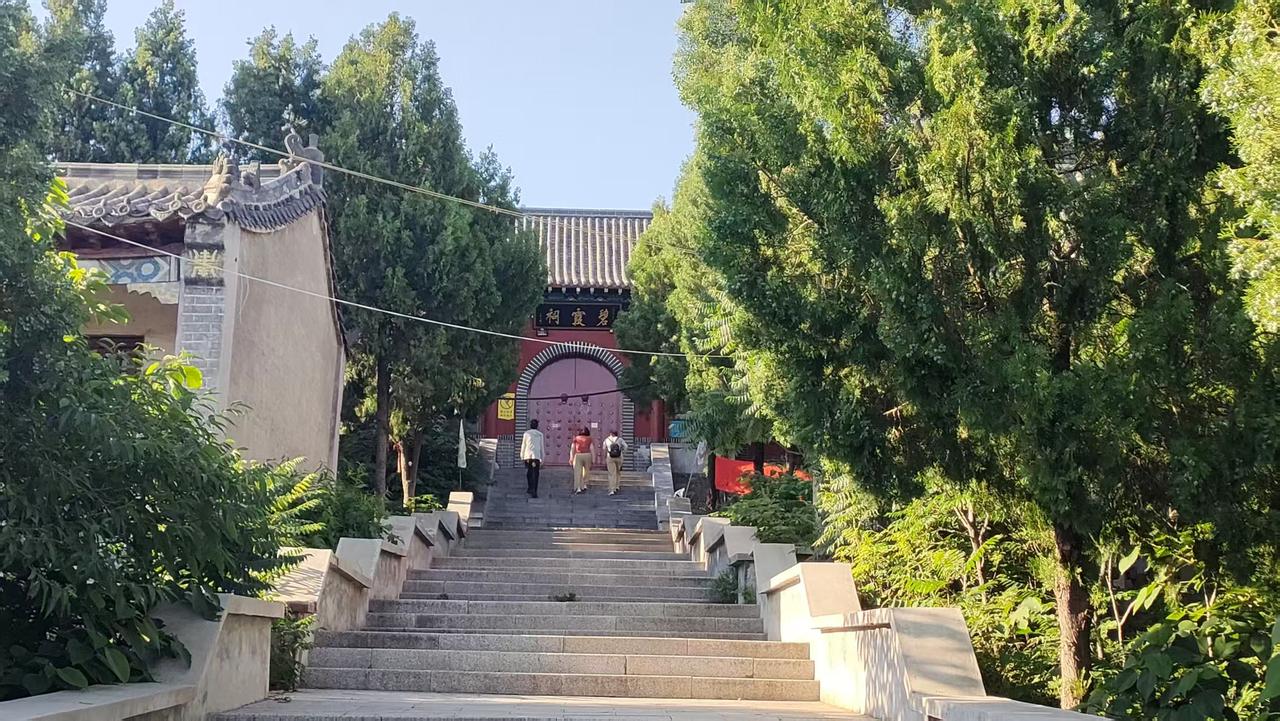 这是莲花山上的碧霞祠。三名信众在碧霞祠门外跪拜碧霞元君。许多人不知道为何莲花山上