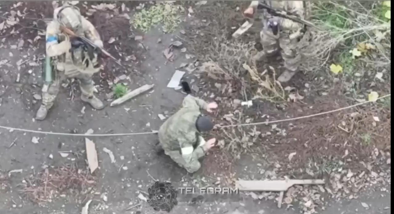 画面令人触目惊心：一名乌克兰士兵在战友的簇拥下，近距离枪杀了一名跪在地上的俄罗斯