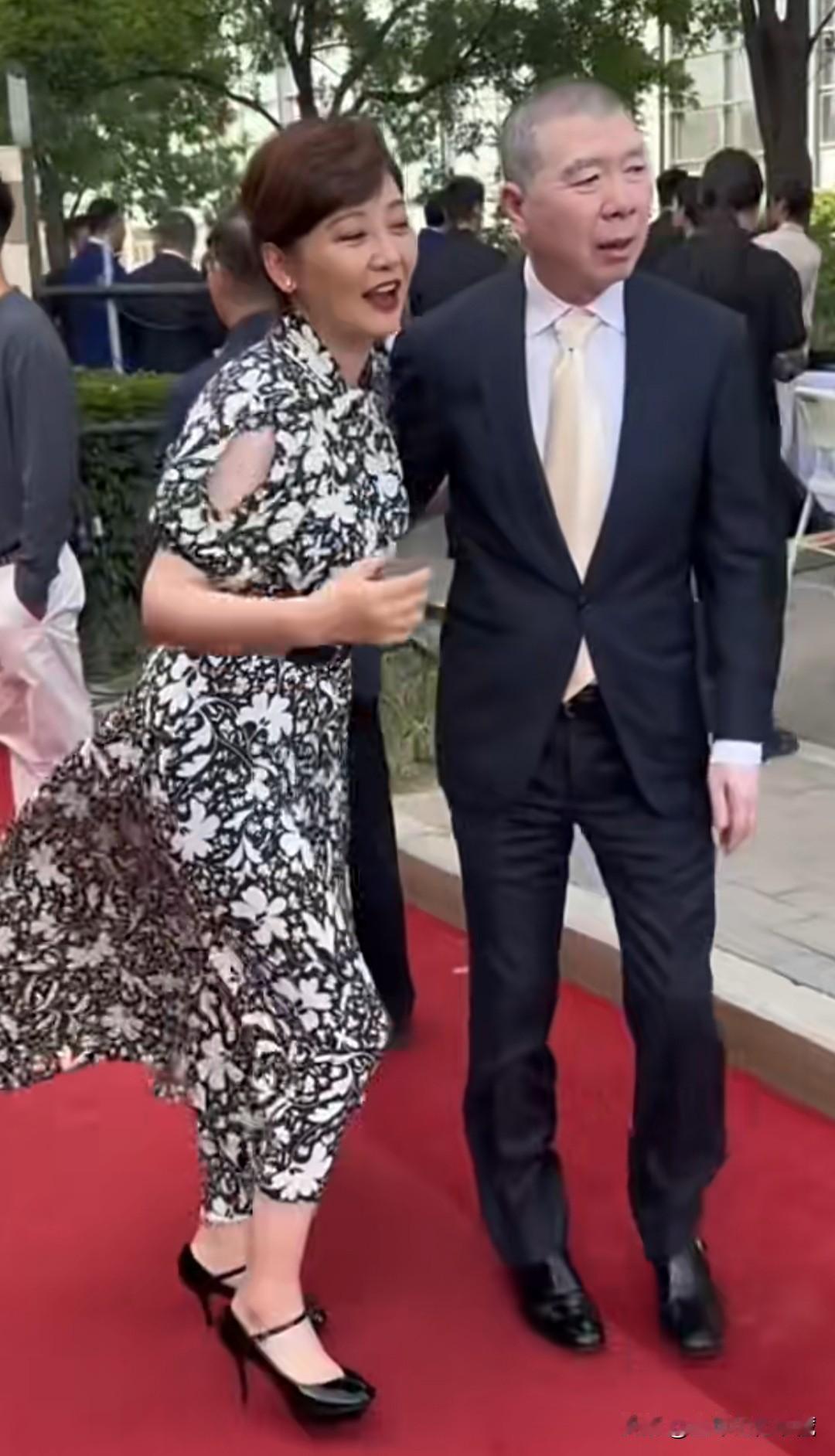 大导演冯小刚和老婆徐帆在水立方前参加活动拍照，徐帆一件黑白花纹连衣长裙，干练的短