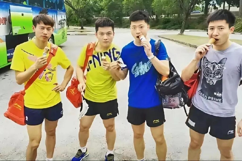 4位乒坛名将吃雪糕靓照：周雨斜挎红包、左手插腰；马龙背着黑包啃着雪糕；樊振东目若