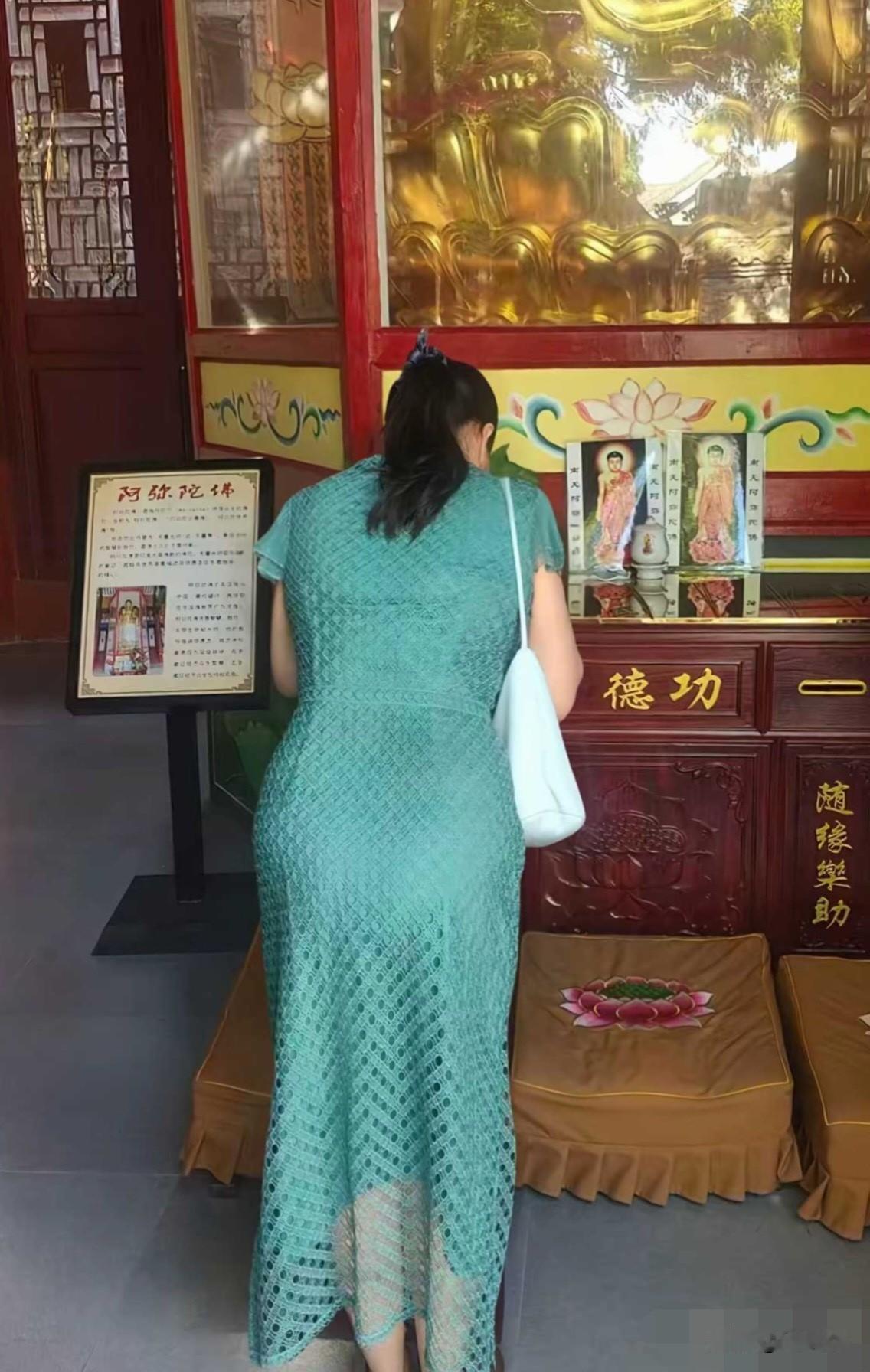 一个女人在寺庙里拜佛。