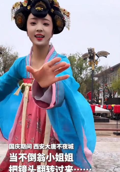 近日，西安大唐不夜城，不倒翁小姐姐表演时，竟然一时兴起，把游客手机抢了过去，将镜