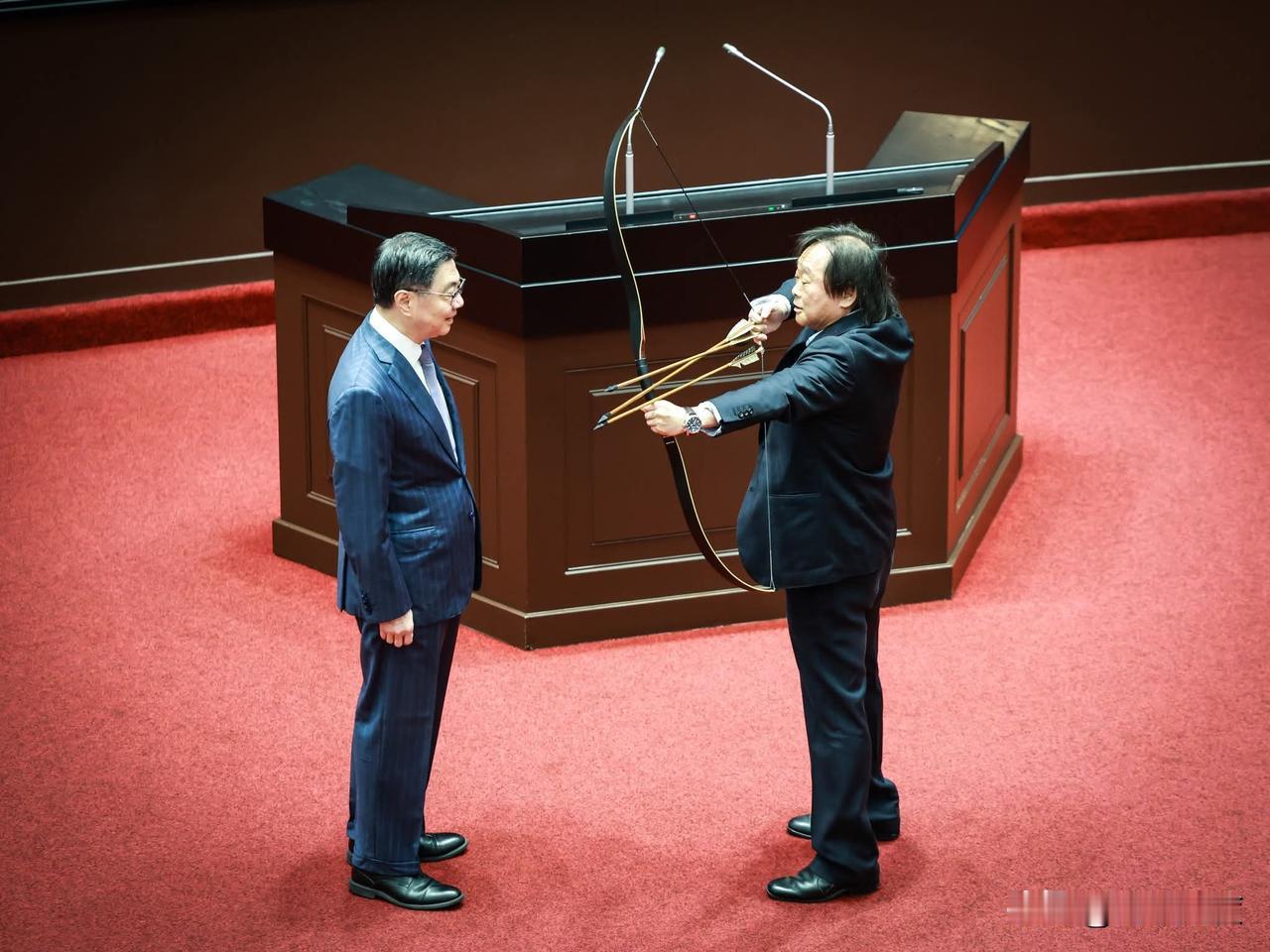 王世坚又来搞笑了，在议场耍起宝来，还真挽弓搭起三只箭，要送给卓荣泰！告知卓荣泰执