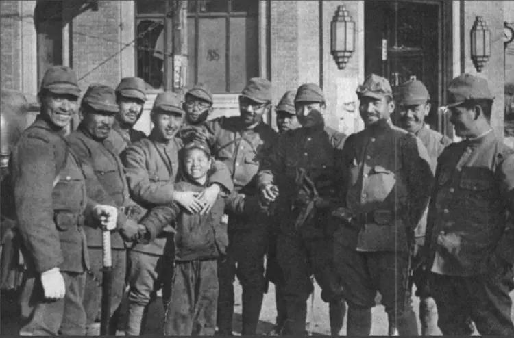 被一群恶狼围住的五六岁的中国小男孩，笑得十分诡异！这一张日军刻意摆拍的老照片，上