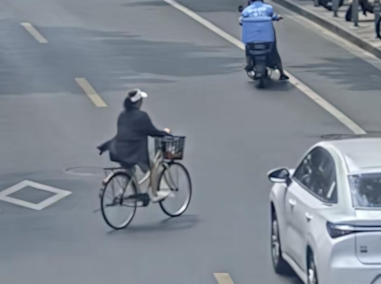 近日，上海普陀区一女子骑自行车横穿马路，与正常行驶的汽车相撞。汽车司机及时踩下刹