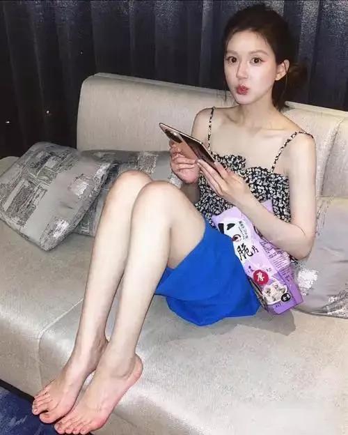 大甜妹赵露思穿着吊带短裤坐在沙发上吃零食的样子好可爱，不过她的这双丑脚丫真的是一