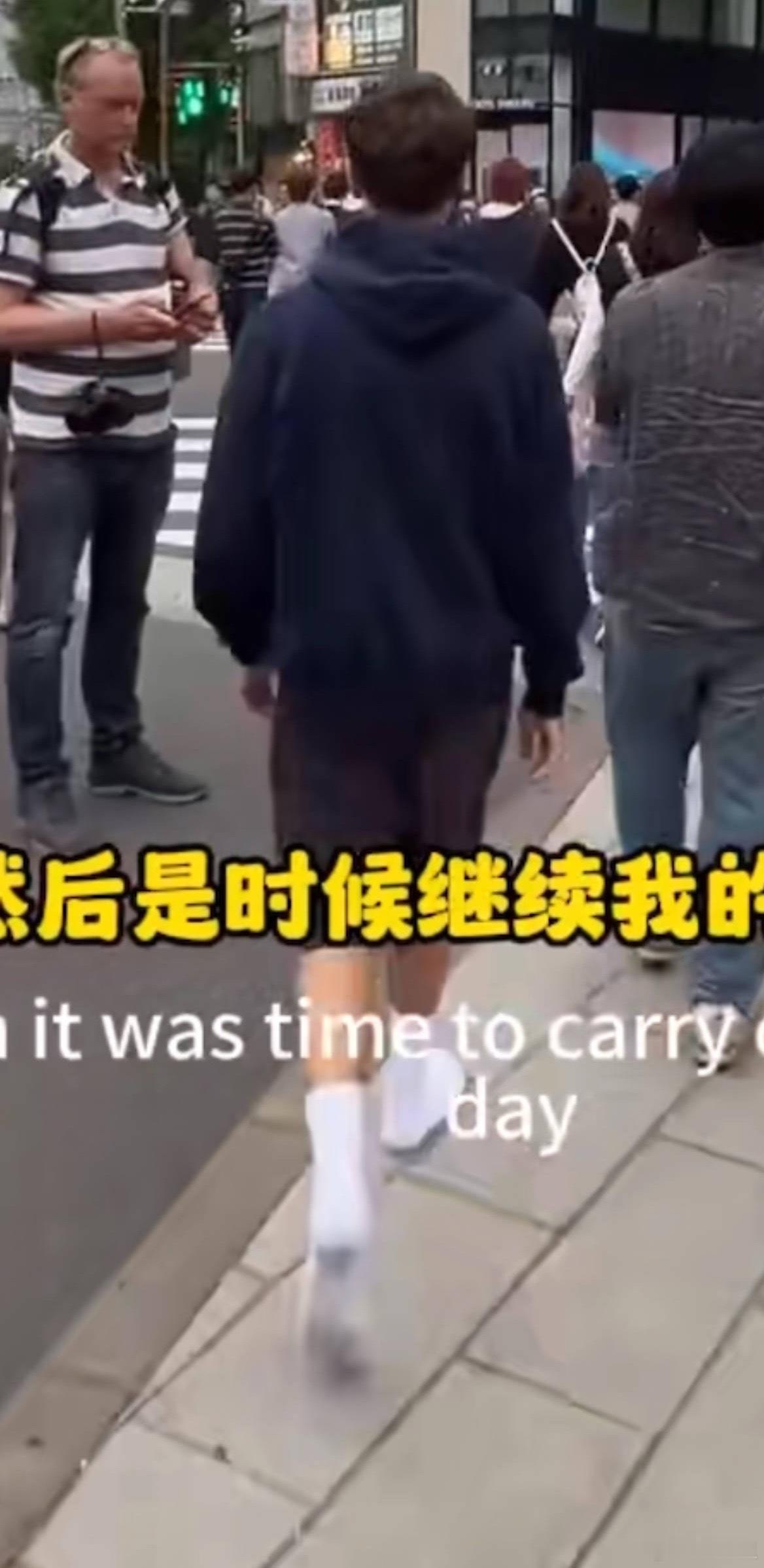外国小哥穿白袜子走在东京街头中间走的时候，露出脚底，可黑了。最后的镜头，换上白的