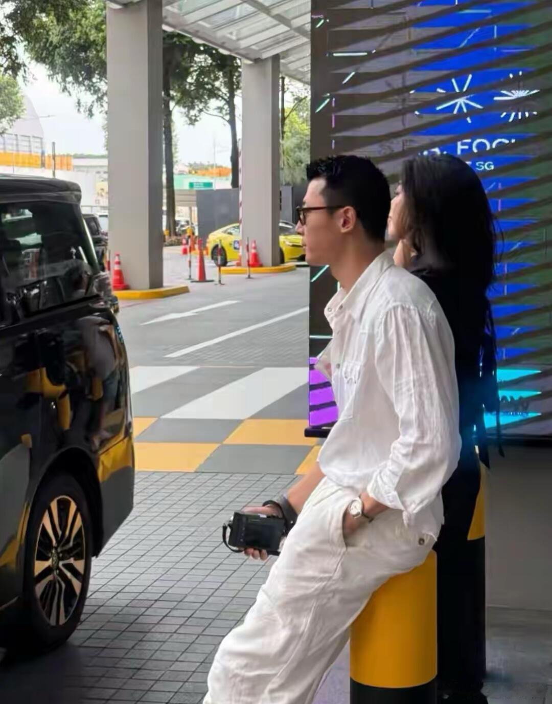 41岁朱珠和老公王昀佳在新加坡路边等车，夫妻俩看起来好时尚。