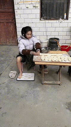 小女孩包包子，手脚并用。这是跟印度人学的吧？好胳膊好腿的健全人，咋能脚踩面皮呢？