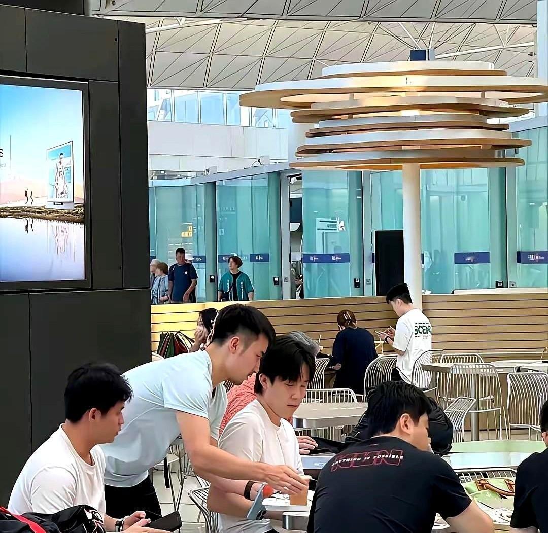 王楚钦今天在香港机场，刚结束训练比赛的小伙子们饿得狼吞虎咽。王楚钦靠在椅子上