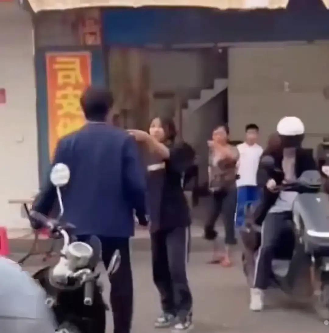 校门口人堆里，有个少年把妹子紧紧挡在身后。对面是六七个
