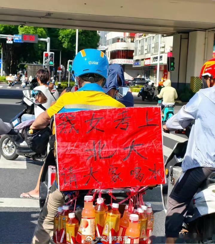 女儿考上北大请大家喝水近日，广西南宁一位骑手因女儿考上北京大学，在电动车上挂满