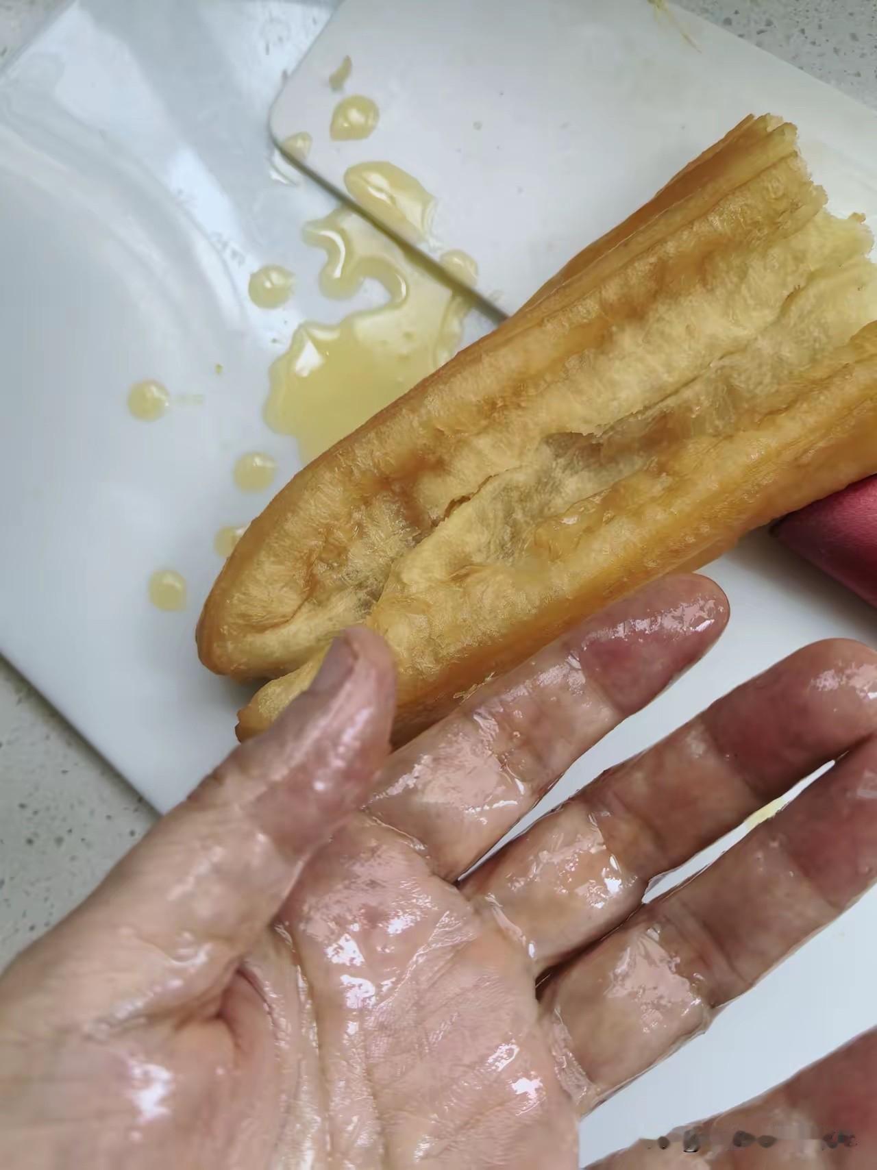 原来这就是隔夜油条啊！一位做早餐的朋友告诉我，这根油条之所以能挤出来这么多的油，