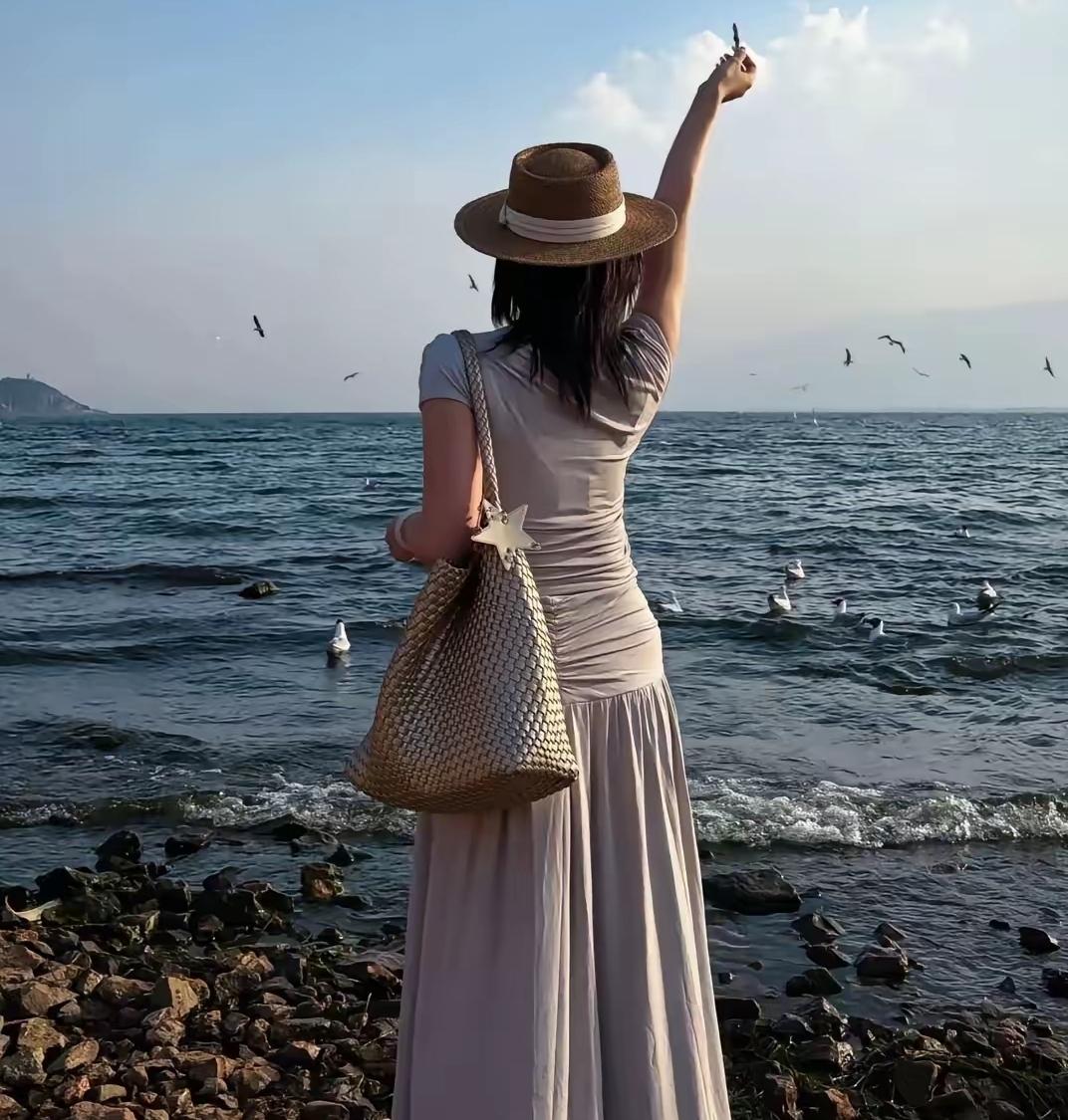 海边漫步，轻纱飘逸，海鸥相伴，悠然自得。原创看图片配诗在海边漫步，那轻纱如同