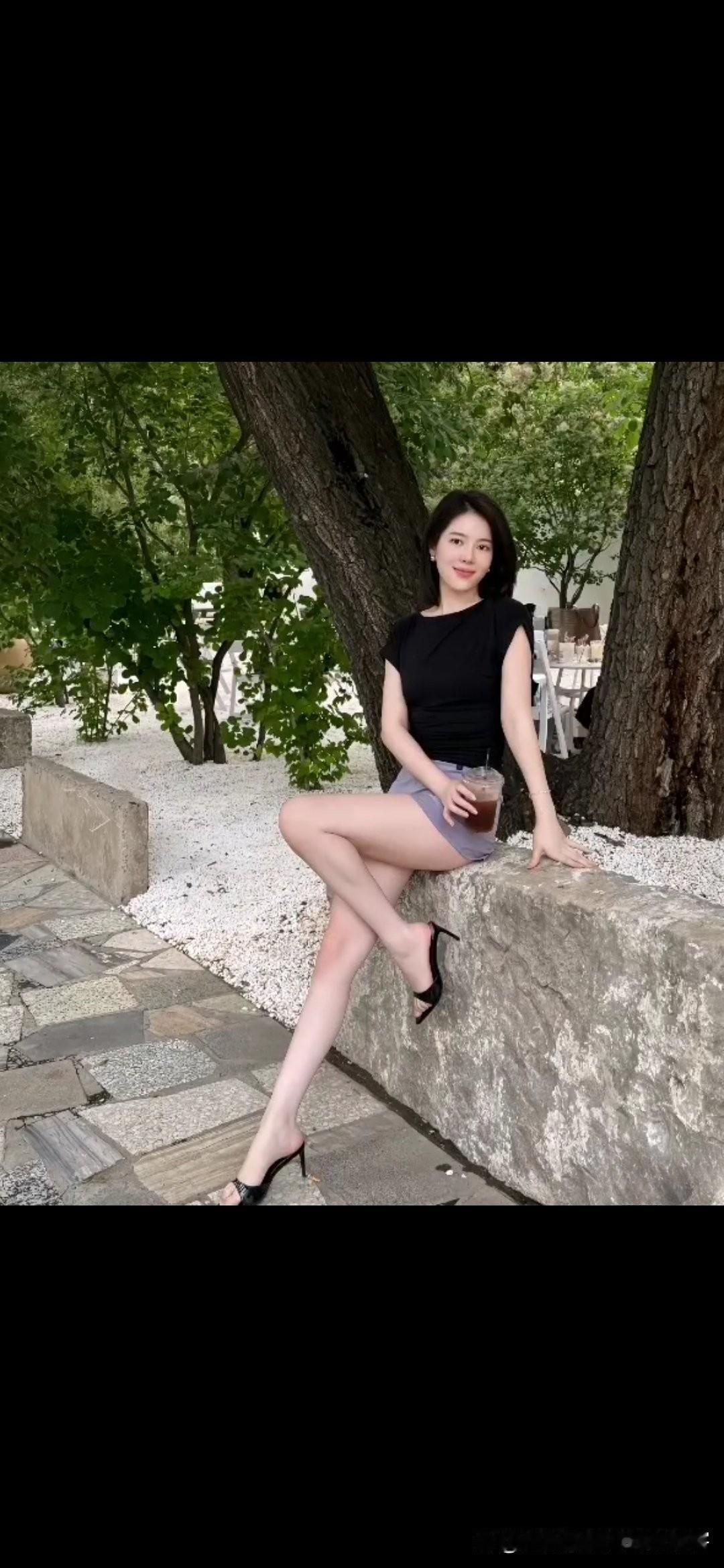 夏日清凉穿搭，黑裙配高跟鞋，树荫下享受一杯冰饮